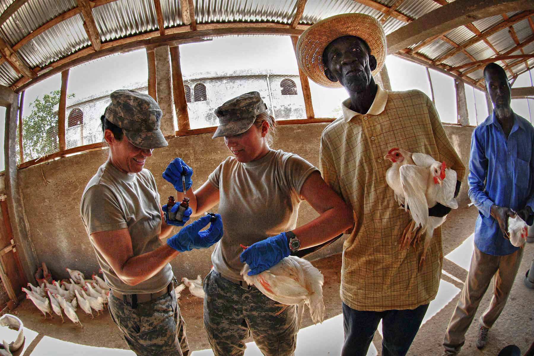 U.S. Army Spcs. Erin Williams, left, and Rachel Kirkey, right, give