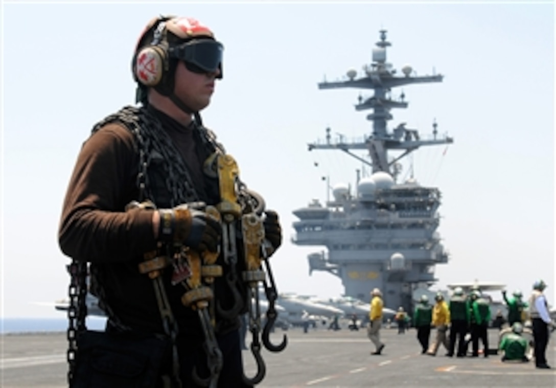 Airman Gregory Bradshaw prepares to secure an aircraft with chains aboard the aircraft carrier USS George H.W. Bush (CVN 77) underway in the Mediterranean Sea on June 16, 2011.  The George H.W. Bush is deployed in support of maritime security operations and theater security cooperation efforts in the U.S. 6th Fleet area of responsibility on its first overseas deployment.  