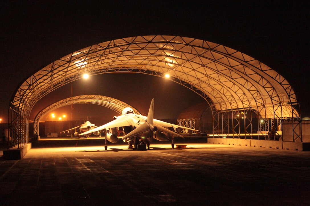 Marine Attack Squadron 513 AV-8B Harriers bathe in the artificial light courtesy of Marine Wing Support Squadron-272 Marines on the runway of Kandahar Airfield, Afghanistan, June 21. MWSS-272 Marines, based in New River, N.C., installed 20 1,000-watt lights on the sunshades covering VMA-513’s Harriers from June 17-21.