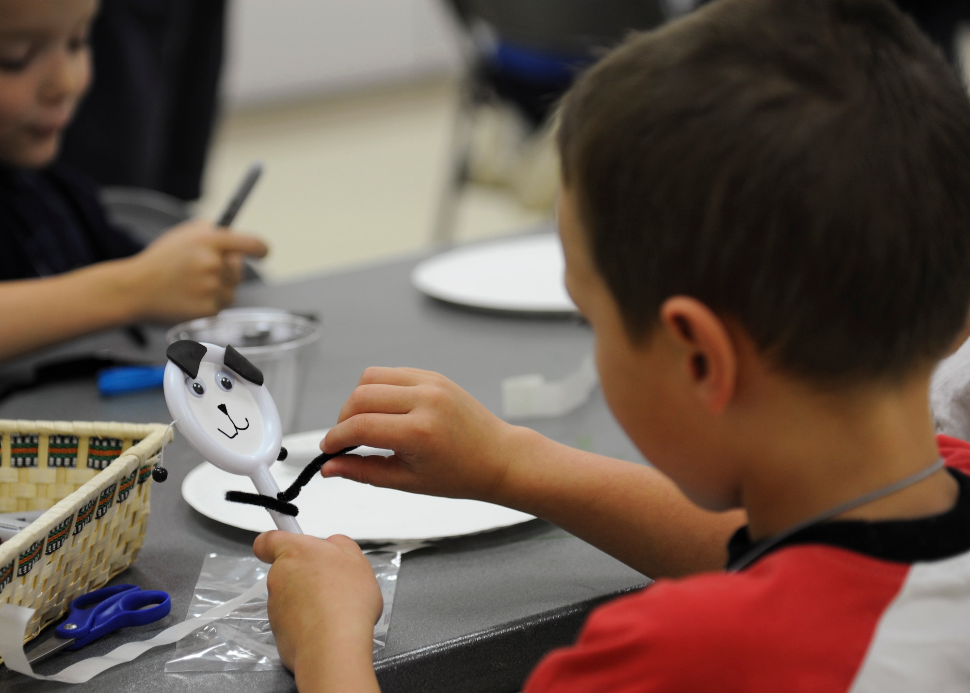 YOKOTA AIR BASE, Japan -- Patrick Nelson, 6, creates a panda spin drum toy during a vacation bible school arts and crafts lesson June 21, 2011, Yokota Air Base, Japan. Approximately 100 children from the base's Protestant and Orthodox Christian communities participated in the weeklong program. (U.S. Air Force photo/Senior Airman Andrea Salazar)