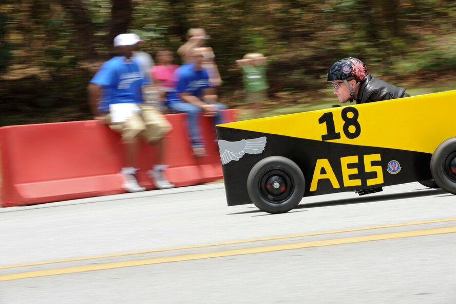 18th Aeromedical Evacuation Squadron’s Maj. Paul Miller, races down the Douglas Boulevard hill during the derby race, June 18. Not only was there a derby race, but the Kadena American Red Cross’s Derby Days also hosted a car show, carnival food, activities and music for families to enjoy. The event was put on in an effort to raise money for local volunteer services.  (U.S. Air Force photo/Airman 1st Class Brooke P. Beers)