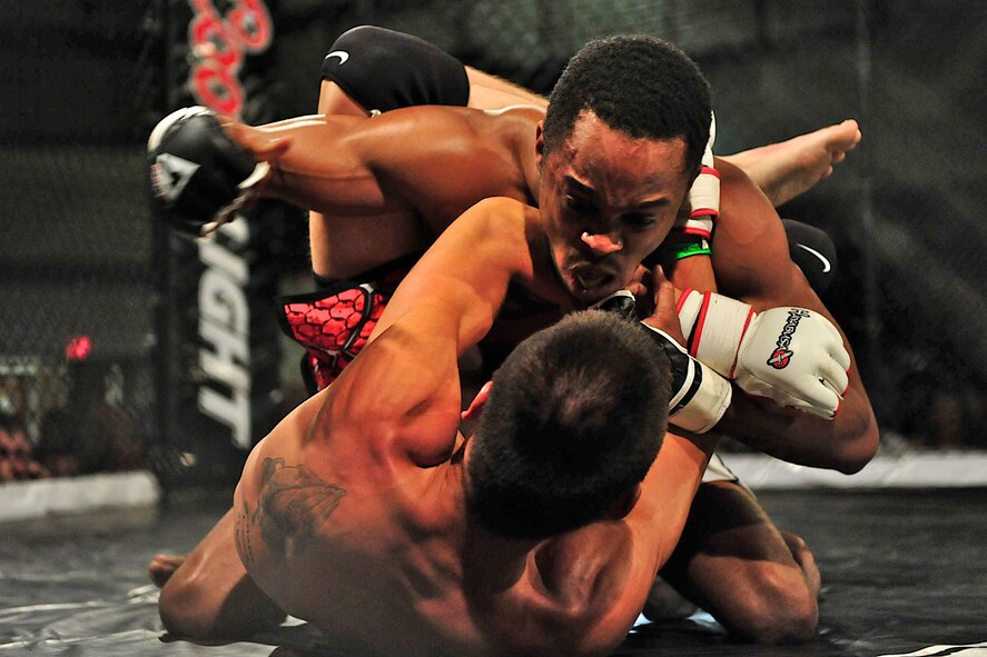 Adrian Harden and Benjamin Booth, mixed martial arts fighters, grapple during a Ring Wars event at Ellsworth Air Force Base, S.D., June 17, 2011. They were invited to fight during the event, which drew more than 700 fans from the Air Force community. (U.S. Air Force photo by Master Sgt. Michael Morford/Released)