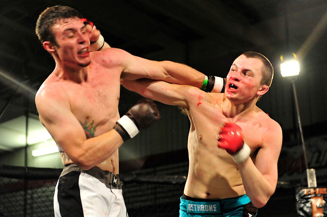 Corbin Nelson, an Air Force family member, lands a right hook to Devin Peterson’s temple during a mixed-martial arts fight at Ellsworth Air Force Base, June 17. The two fought during a Ring Wars event held at the base’s Bellamy Fitness Center. (U.S. Air Force photo/Master Sgt. Michael Morford/Released)