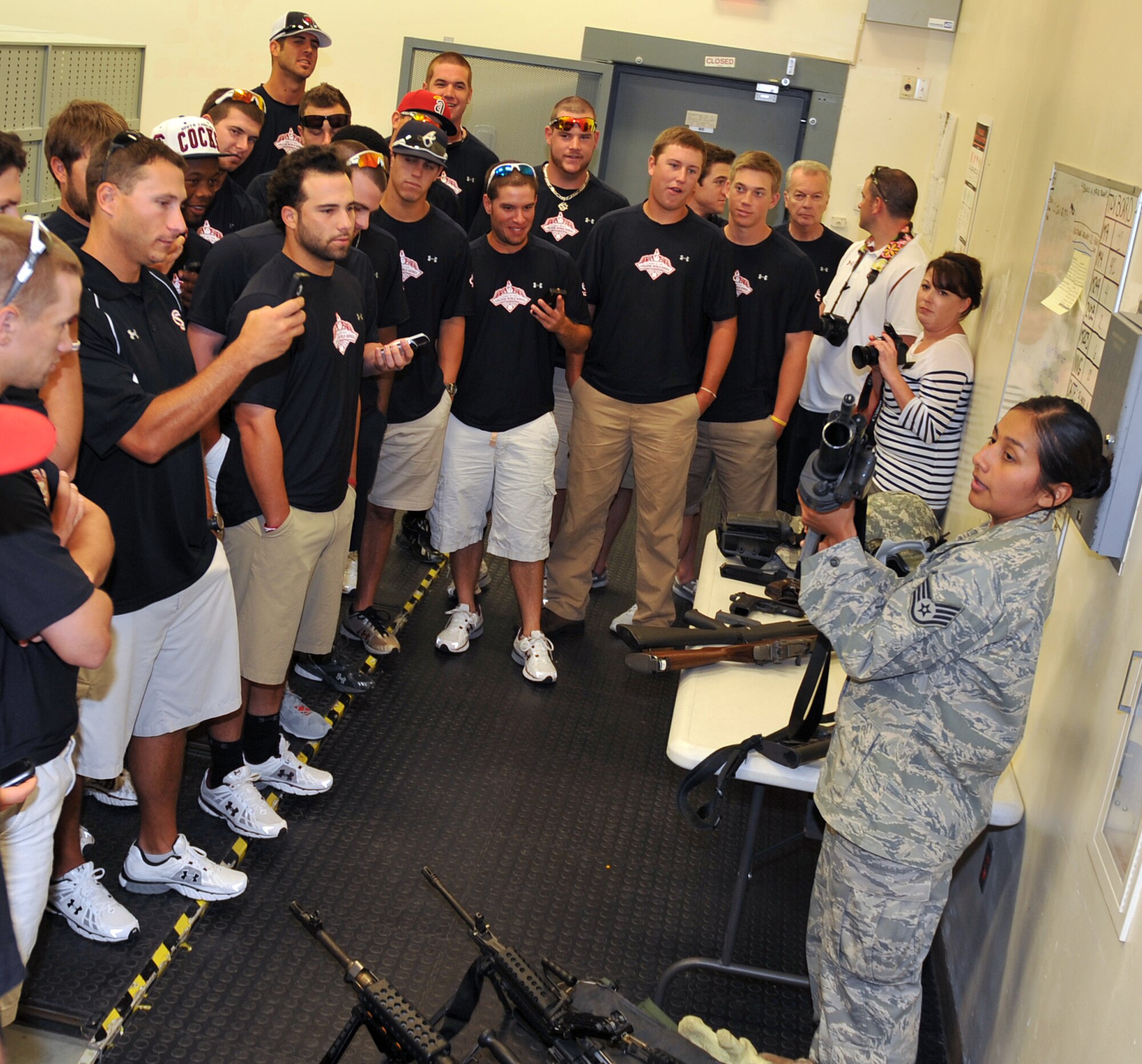 U.S. Air Force Staff Sgt. Tracy Howard, 55th Security Forces Squadron describes various types of weaponry to members of the University of South Carolina Gamecocks Baseball Team in the 55th Security Forces armory on Offutt Air Force Base, Neb., June 20. The 55th Wing sponsors a different baseball team each year at the College World Series, ensuring the team can focus on playing. Each year, the team is invited to a tour of Offutt and luncheon with base leadership. (U.S. Air Force photo by Jeff Gates/Released)