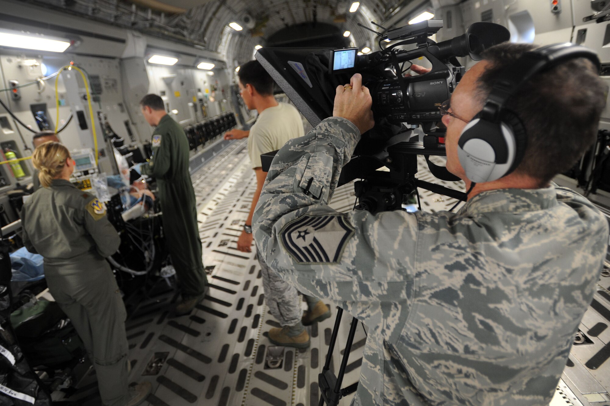 Master Sgt. Thomas Taylor, broadcaster with the Pacific Air Forces Public Affairs Office , films a simulated casualty evacuation for a video highlighting the Pacific Air Forces mission June 16. The video will be comprised of multiple scenes involving units from Joint Base Pearl Harbor-Hickam, Hawaii, as well as other bases and squadrons throughout the PACAF. (U.S. Air Force photo/Senior Airman Lauren Main)