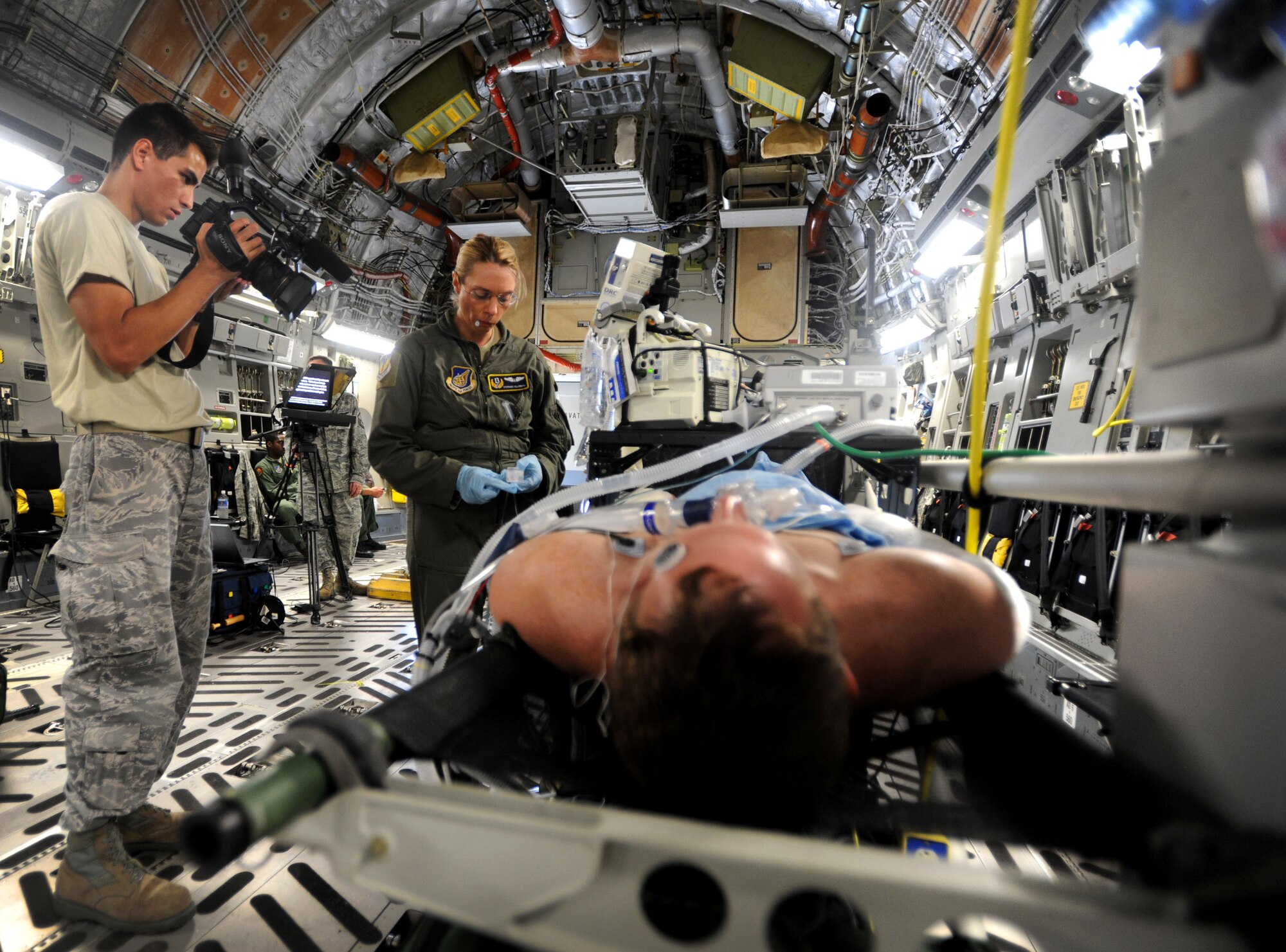 Staff Sgt. Anthony Gomez, broadcaster with the 15th Wing Public Affairs Office, films a simulated casualty evacuation for a video highlighting the Pacific Air Forces mission June 16. The video will be comprised of multiple scenes involving units from Joint Base Pearl Harbor-Hickam, Hawaii, as well as other bases and squadrons throughout the PACAF. (U.S. Air Force photo/Senior Airman Lauren Main)