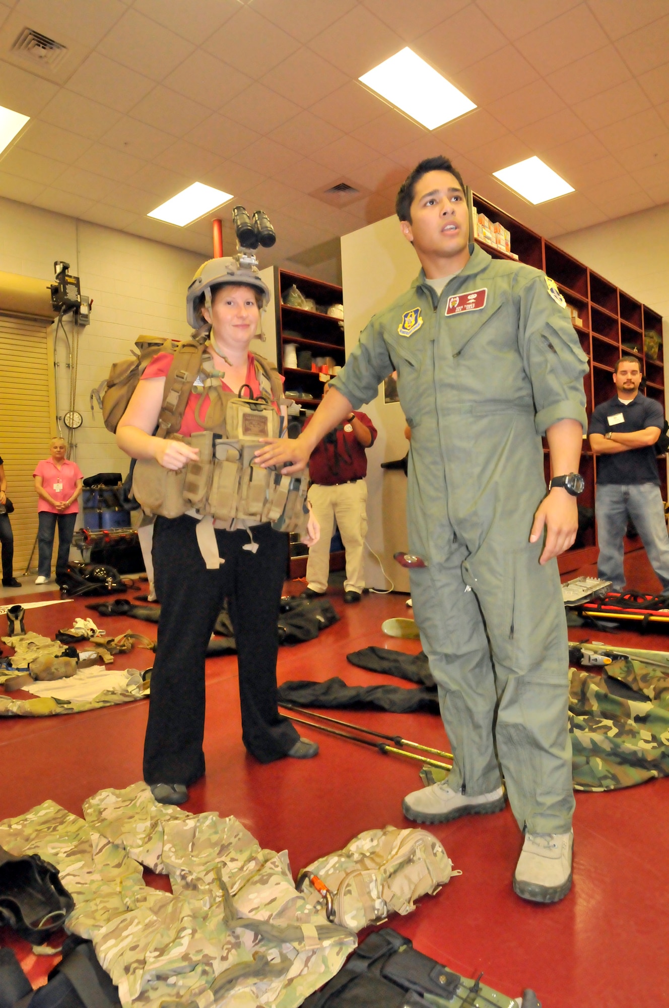 PATRICK AIR FORCE BASE, Fla.- Senior Airman Kristopher Tomes, a 920th Rescue Wing pararescueman here, straps Christina Brown, owner of Roses are Red Florist, with all the gear a PJ is required to wear when doing a jump from an aircraft. PJs participate in search and rescue, combat search and rescue, recovery support for NASA and conduct other operations as appropriate. (U.S. Air Force photo/Airman First Class Natasha Dowridge)
