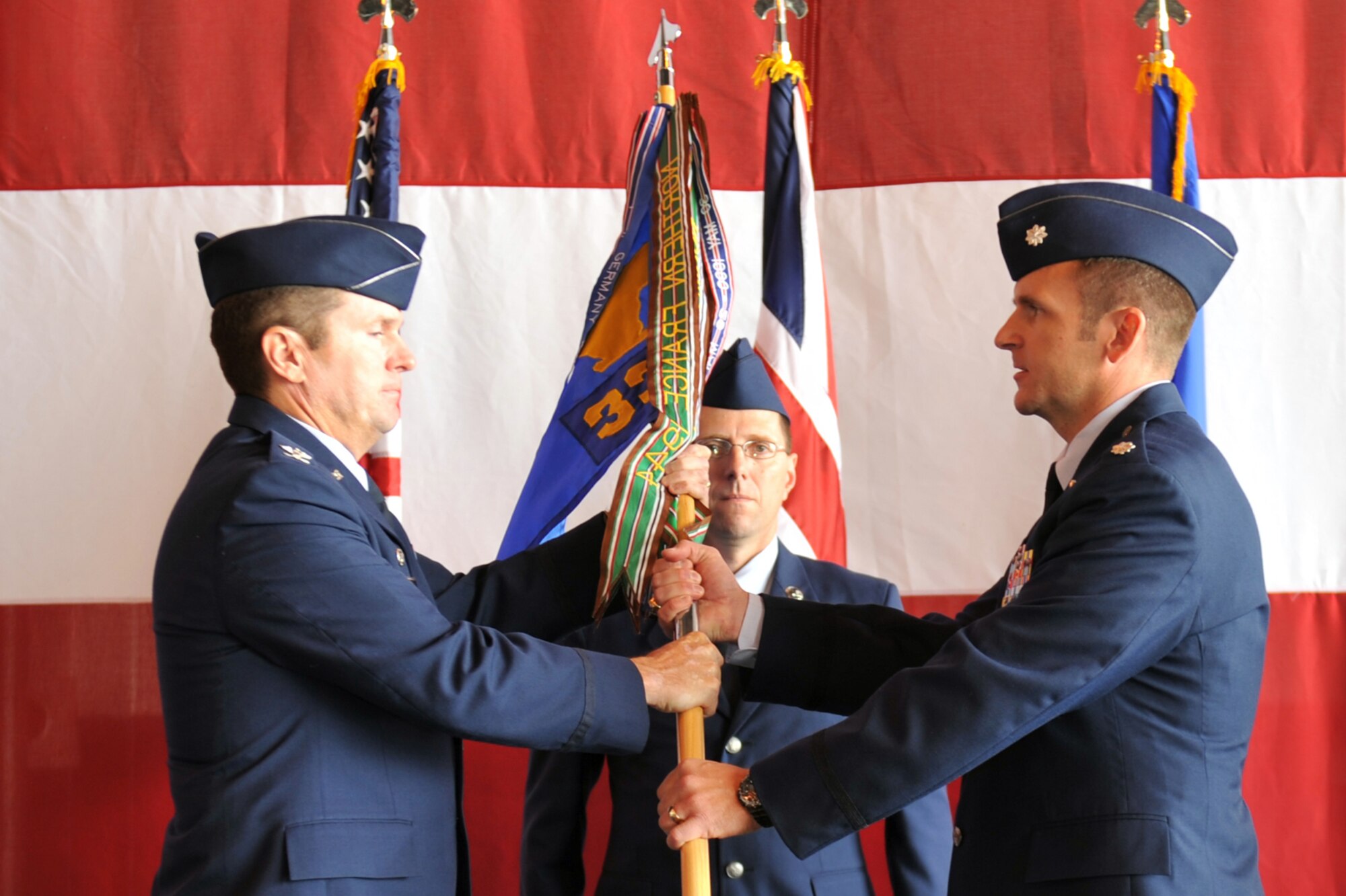 Air Force Col. John M. Hansen, 55th Operations Group commander, passes the guidon to Air Force Lt. Col. Douglas P. Rice, incoming commander for the 338th Combat Training Squadron during a change of command ceremony at the Bennie L. Davis Maintenance Facility on June 17, 2011, on Offutt Air Force Base, Neb.  Colonel Rice comes to Offutt after serving as the director of operations for the 763rd Expeditionary Reconnaissance Squadron, Al Udeid Air Base, Southwest Asia. (U.S. Air Force photo by Jeff W. Gates/Released)