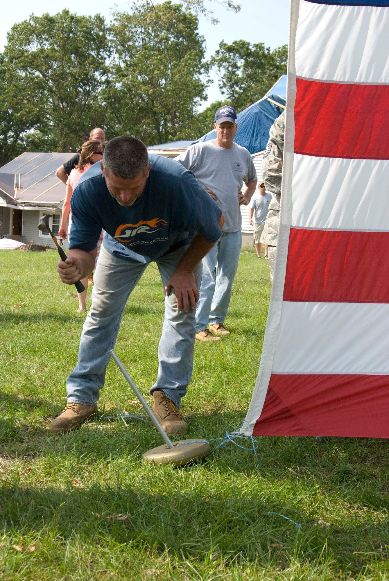 Members of the Security Forces and the 337th Airlift Squadron at Westover ARB donated an installation flag June 15 to Master Sgt. Daniel Sullivan, a resident of Springfield, Mass., who was hit hard by the June 1 tornadoes. For the past decade Master Sgt. Sullivan has displayed a large flag in his front yard. After the tornadoes, his flag was in a state of disrepair.