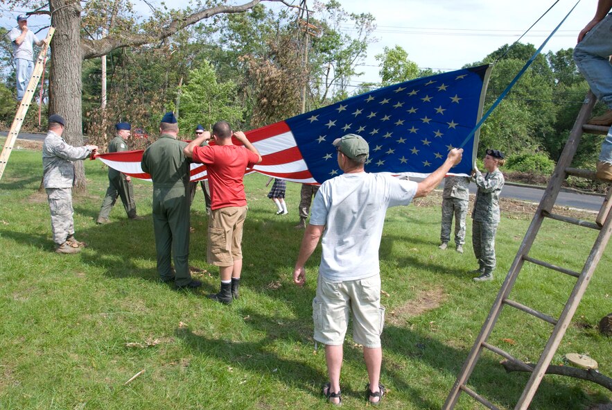 Members of the Security Forces and the 337th Airlift Squadron at Westover ARB donated an installation flag June 15 to Master Sgt. Daniel Sullivan, a resident of Springfield, Mass., who was hit hard by the June 1 tornadoes. For the past decade Master Sgt. Sullivan has displayed a large flag in his front yard. After the tornadoes, his flag was in a state of disrepair.