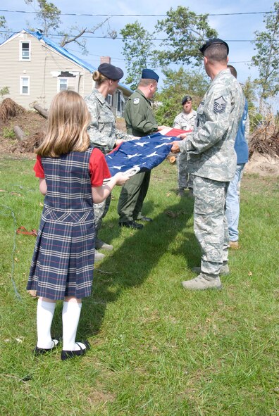 Members of the Security Forces and the 337th Airlift Squadron at Westover ARB donated an installation flag June 15 to Master Sgt. Daniel Sullivan, a resident of Springfield, Mass., who was hit hard by the June 1 tornadoes. For the past decade Master Sgt. Sullivan has displayed a large flag in his front yard. After the tornadoes, his flag was in a state of disrepair.