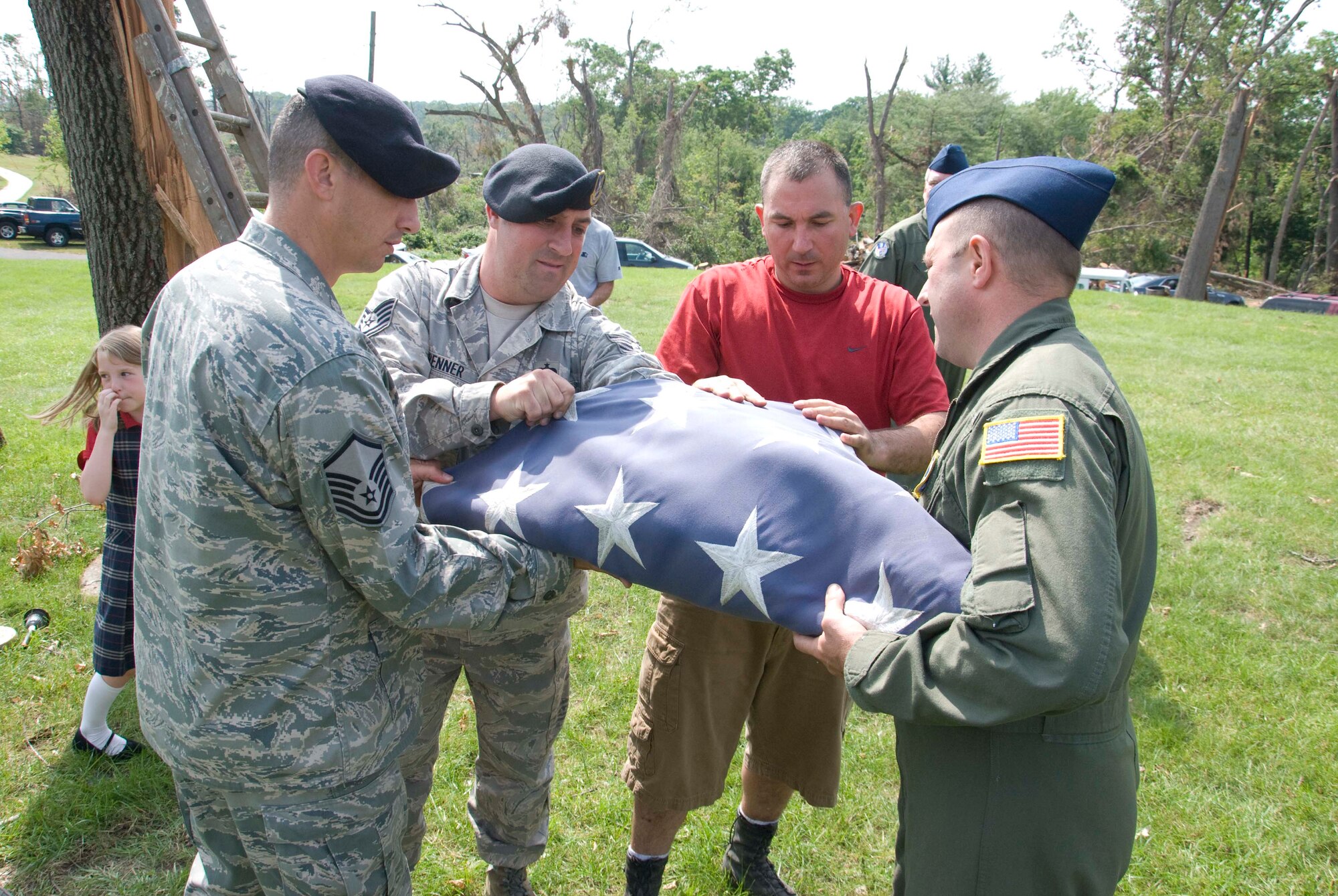Members of the Security Forces and the 337th Airlift Squadron at Westover ARB donated an installation flag June 15 to Master Sgt. Daniel Sullivan, a resident of Springfield, Mass., who was hit hard by the June 1 tornadoes. For the past decade Master Sgt. Sullivan has displayed a large flag in his front yard. After the tornadoes, his flag was in a state of disrepair.