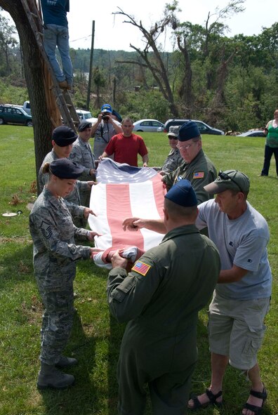 Members of the Security Forces and the 337th Airlift Squadron at Westover ARB donated an installation flag June 15 to Master Sgt. Daniel Sullivan, a resident of Springfield, Mass., who was hit hard by the June 1 tornadoes. For the past decade Master Sgt. Sullivan has displayed a large flag in his front yard. After the tornadoes, his flag was in a state of disrepair.