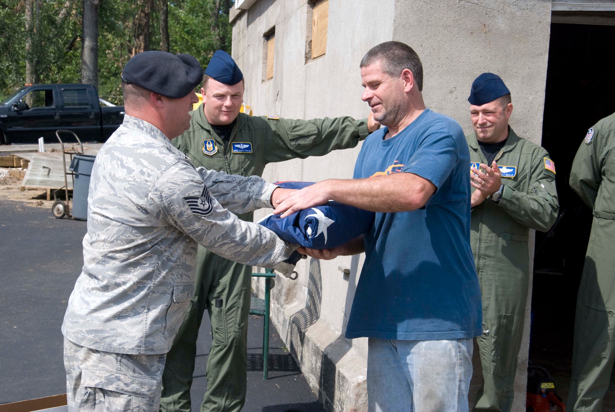 Members of the Security Forces and the 337th Airlift Squadron at Westover ARB donated an installation flag June 15 to Master Sgt. Daniel Sullivan, a resident of Springfield, Mass., who was hit hard by the June 1 tornadoes. For the past decade Master Sgt. has displayed a large flag in his front yard. After the tornadoes, his flag was in a state of disrepair.