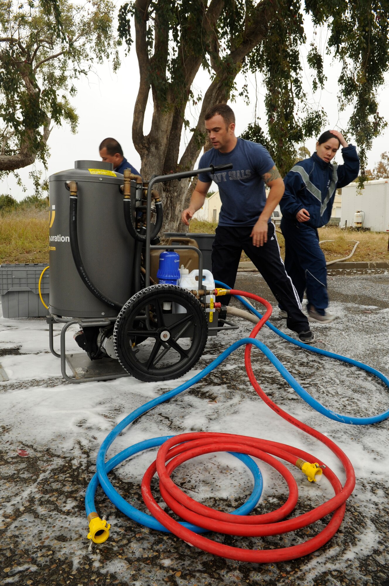 VANDENBERG AIR FORCE BASE, Calif. – Three members of the 30th Medical Group set up a hot water pump during a timed trial to complete the In Place Patient Decontamination training at the clinic here Thursday, June 16, 2011. The training is designed to prepare Airmen to provide care during a chemical, biological, radiological or nuclear catastrophe. (U.S. Air Force photo/Senior Airman Lael Huss)