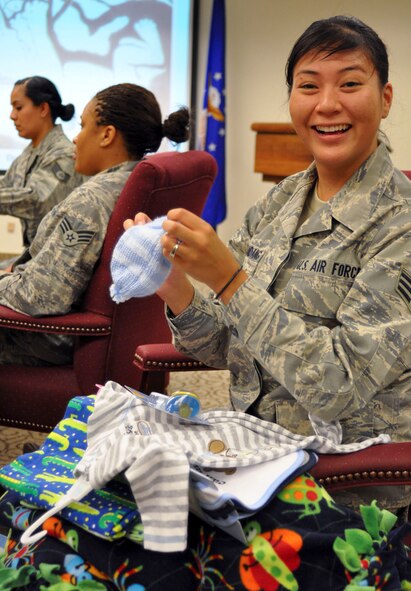 Senior Airman Ashley Carandang, 4th Combat Camera Squadron, is excited to find a tiny, hand crocheted infant hat in her gift bag at the Bundles for Babies course at March Air Reserve Base, Calif., June 7, 2011. Airman Carandang is expecting her first child in November and found out a week before the class that it is going to be a boy. (U.S. Air Force photo/Megan Just)