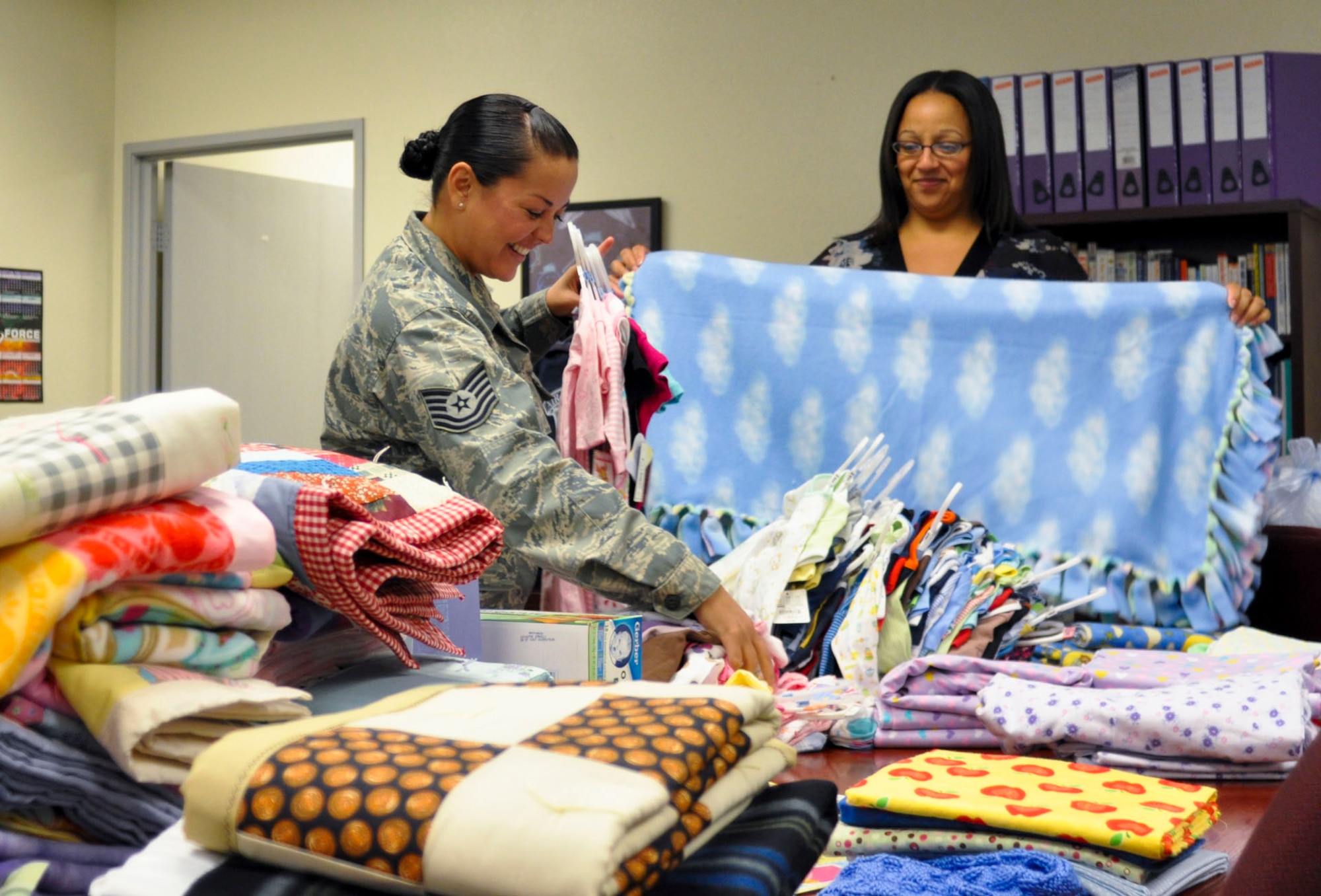 Tech. Sgt. Crystal Goff (left), 912th Air Refueling Squadron Airman and Family Readiness NCO, and Devina Whitt-Snyder, 452nd Air Mobility Wing Airman and Family Readiness administrative assistant, sort though donated baby clothing and blankets for the Bundles for Babies class at March Air Reserve Base, Calif., June 7, 2011. Bundles for Babies is an Air Force Aid Society sponsored course that helps expectant parents be prepared for the costs of raising a child. (U.S. Air Force photo/Megan Just)