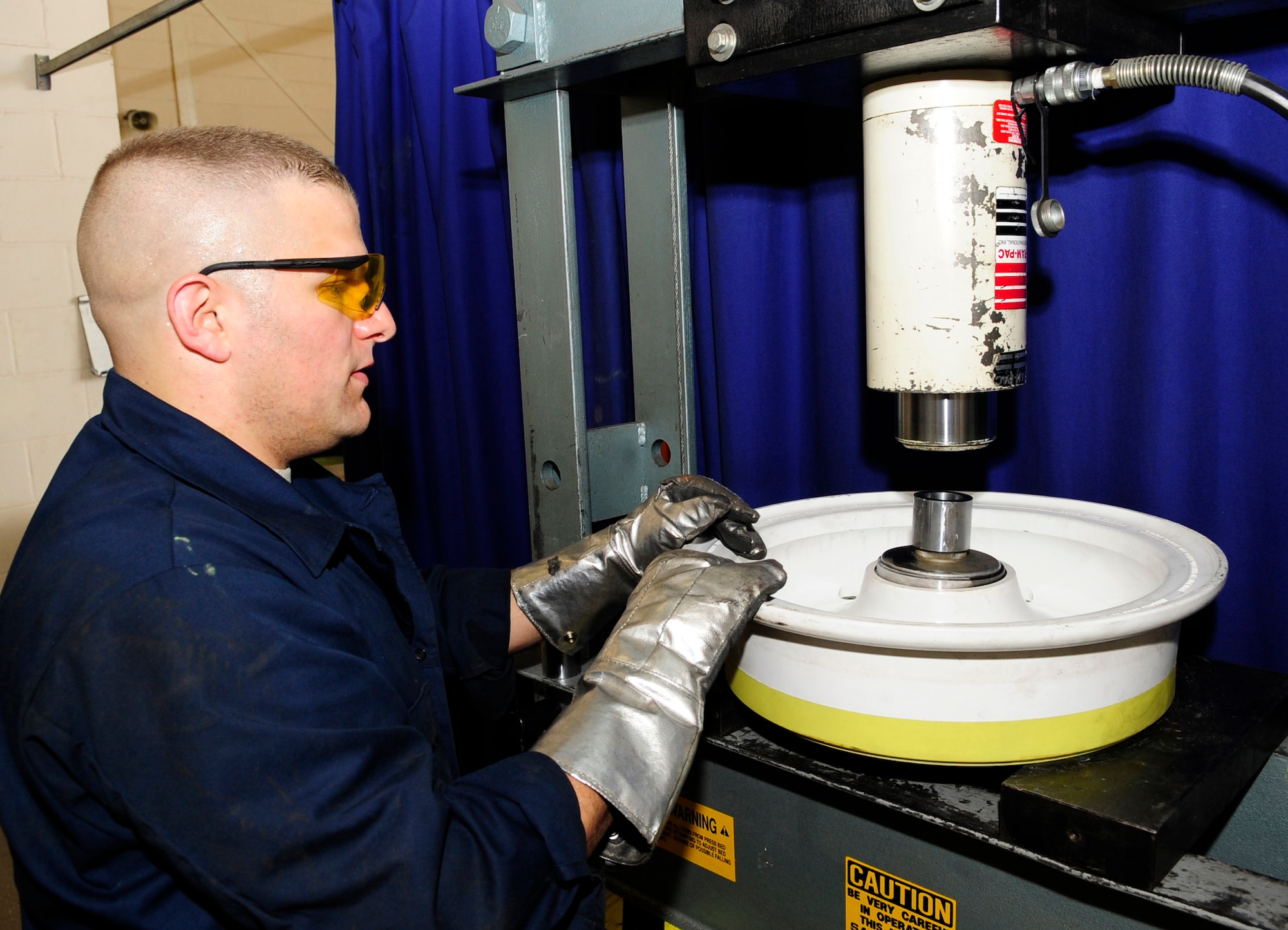 RAF MILDENHALL, England -- Tech. Sgt. Preston Gallegos, 100th Maintenance Squadron aero repair craftsman, monitors a hydraulic press being lowered onto a bearing cup being replaced in a KC-135 Stratotanker nose landing wheel here June 15, 2011. To fit inside the wheel the bearing cup must be frozen to minus 20 degrees to ensure it’s properly sized. (U.S. Air Force photo/Senior Airman Ethan Morgan)
