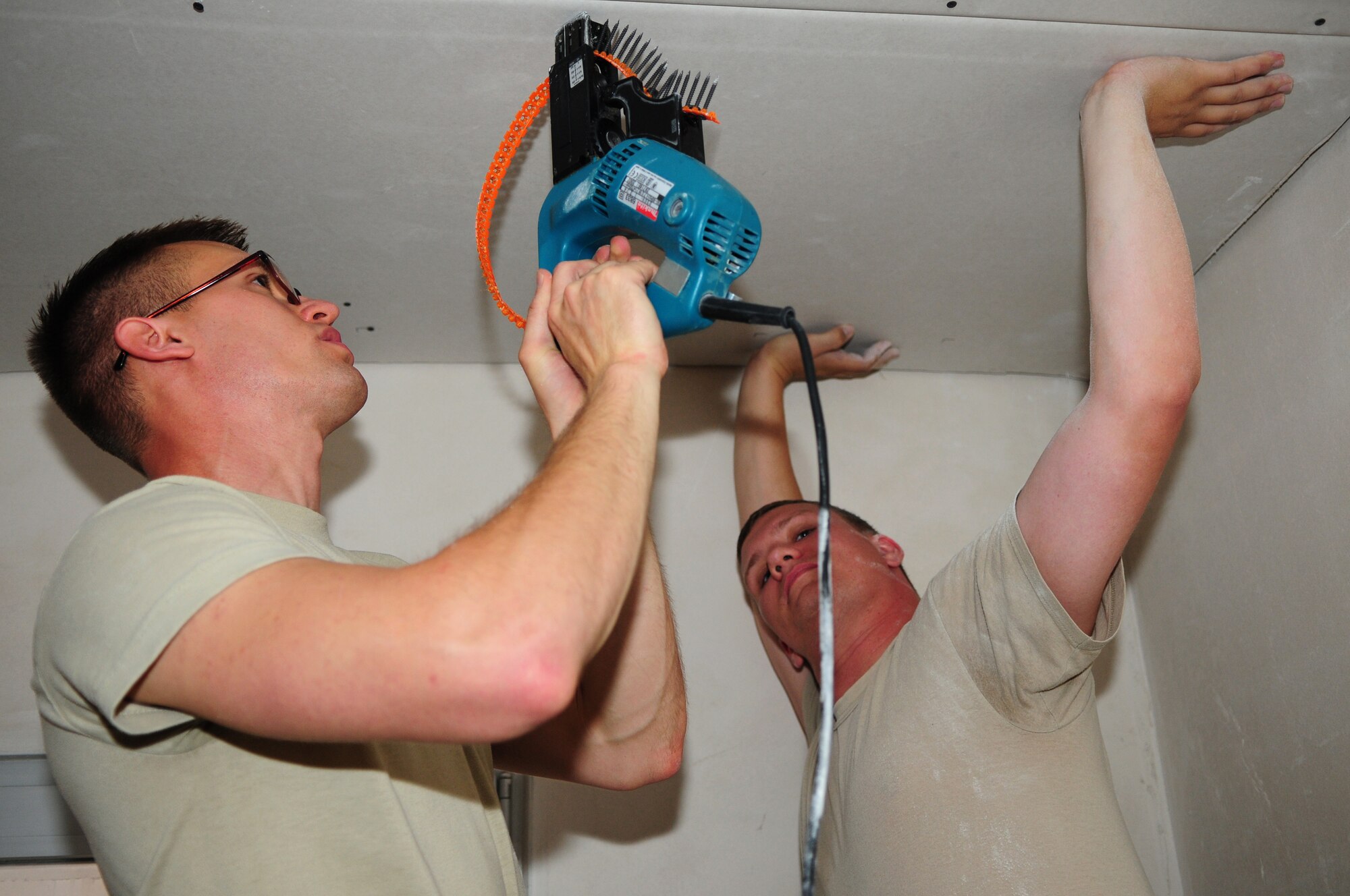 SPANGDAHLEM AIR BASE, Germany – Airman 1st Class Keegan Seymour, 52nd Civil Engineer Squadron structural apprentice, screws into place sheetrock held up by Senior Airman Jeffrey Le Tourneau, 52nd CES structural journeyman, while working on a remodeling project here June 21. The structures flight within the 52nd CES is responsible for all emergency, urgent and routine work orders for carpentry, locksmithing, masonry and metalwork on Spangdahlem Air Base and 18 geographically separated units. (U.S. Air Force photo/Airman 1st Class Matthew B. Fredericks)