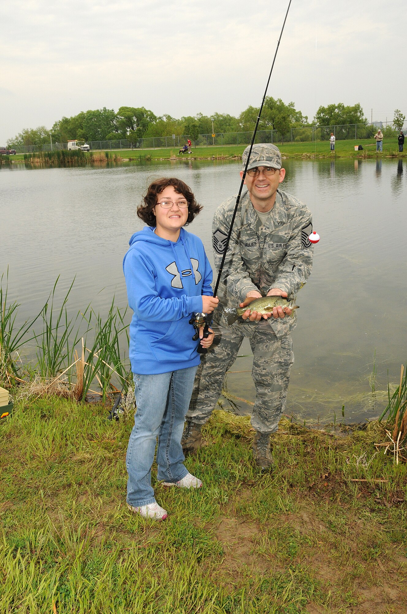 Rachel, (left) a senior at Lincoln Northstar High school enrolled in the Functional Community Reference program, and her fishing buddy Master Sgt. Aaron Aulner, 155th Air Refueling Wing Prime Ribs manager, show off a fish they caught on May 20, 2011 during the annual "Gators Gone Fishin". This is the second year Rachel and Master Sgt. Aulner paired together to catch fish and enjoy the event. (Nebraska Air National Guard photo by Senior Master Sgt. Lee Straube)
