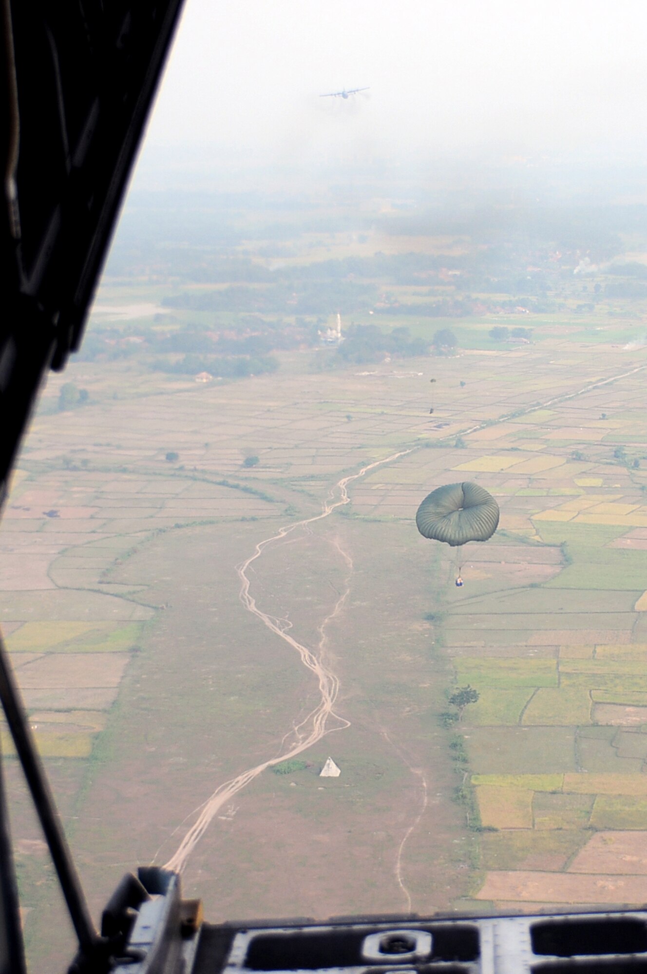 GORDA DROP ZONE, Indonesia -- A Container Delivery System pallet descends from a C-130 Hercules with the 36th Airlift Squadron from Yokota Air Base, Japan, during Exercise Cope West 11 over the Gorda drop zone, Indonesia, June 21, 2011. During the exercise, the U.S. and Indonesian Air Forces exchange and practice airlift, air-land, and airdrop delivery techniques to enhance their ability to respond to regional disasters. (U.S. Air Force photo/Capt. Raymond Geoffroy)