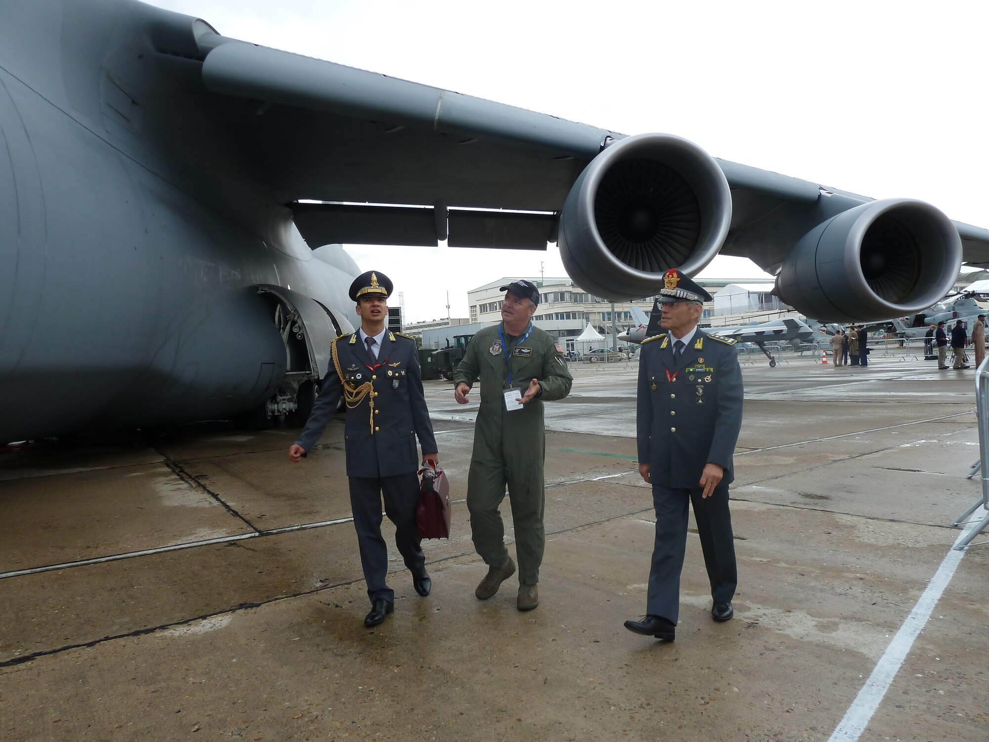 Lt. Col. Mark Alderson (center), a pilot with 709th Airlift Squadron at Dover Air Force Base, Del., tells an Italian army lieutenant general (right) about the capabilities of C-5M Super Galaxy. The C-5M is one of the 11 U.S. aircraft on display at the 49th International Paris Air Show, Le Bourget Airport, France, June 20-26. (U.S. Air Force photo/Tech. Sgt. Francesca Popp)