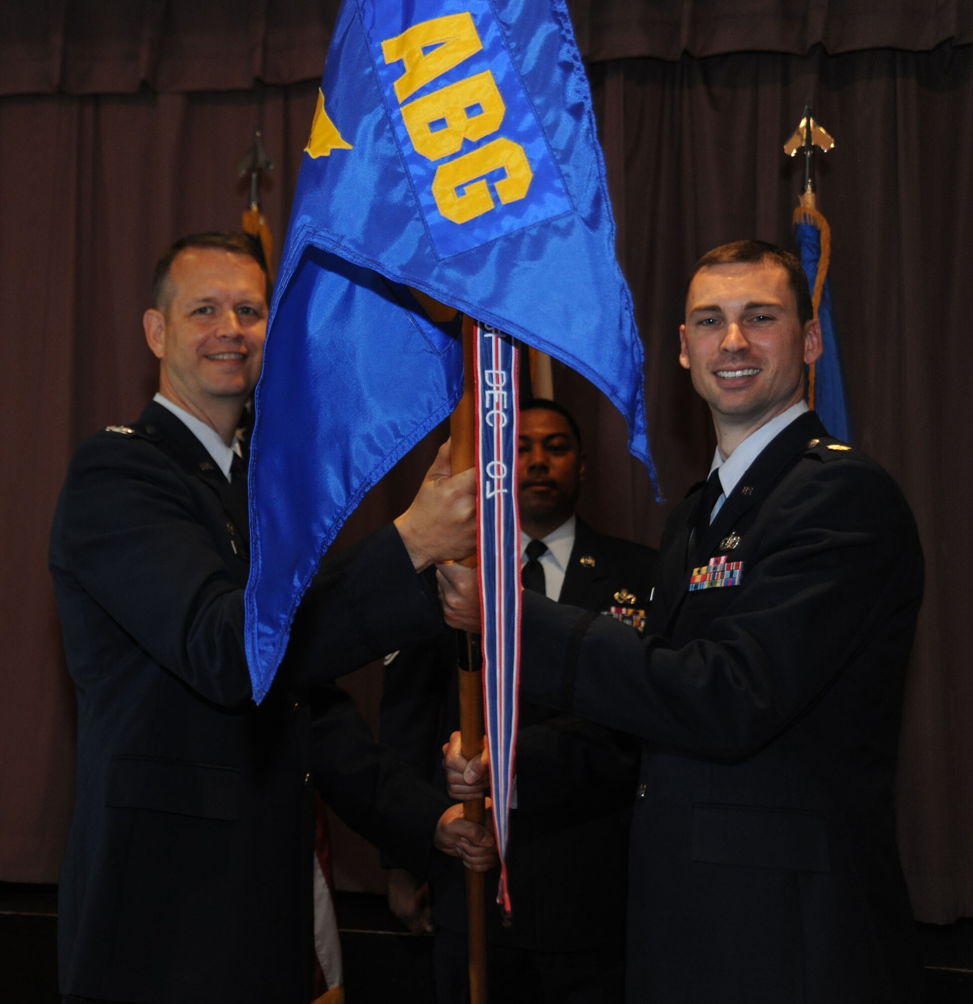 Colonel Jeffrey Renner hands the guidon to Maj. Ross Gleason during a change of command ceremony June 21 at RAF Croughton. Colonel Renner is the 422nd Air Base Group commander and Maj. Gleason is the incoming 422nd Civil Engineer Squadron commander.