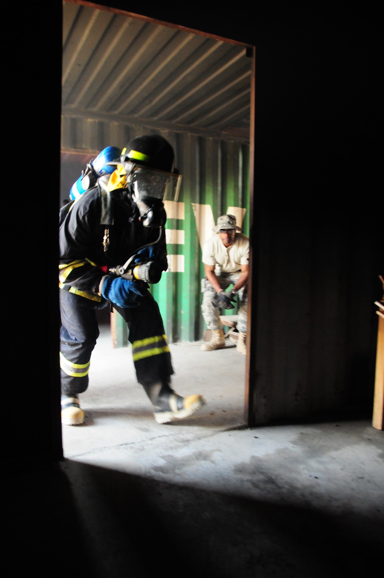 KABUL, Afghanistan -- A firefighter from the Afghan Air Force, rushes into a controlled burn exercise while conducting training at the Kabul International Airport, June 21, 2011.  Coalition forces work shoulder-to-shoulder with the AAF in an advisory role. (U.S. Air Force photo by Senior Airman Amber Williams)