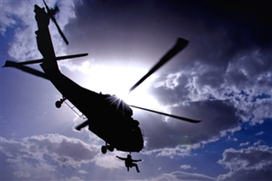 A U.S. Special Operations team member is hoisted into a UH-60 Black Hawk helicopter during a medical evacuation training exercise on Multinational Base Tarin Kowt in Uruzgan province, Afghanistan, on June 13, 2011.  