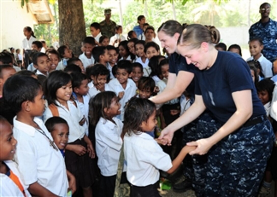 Ensign Allison Luzwick (left) and Yeoman 2nd Class Victoria Kent dance with Timorese students at Manleuana Primary School during a community service event for the Timor-Leste phase of Pacific Partnership 2011 in Dili, Timor-Lest, on June 20, 2011.  Pacific Partnership is a five-month humanitarian assistance initiative that will make port visits to Tonga, Vanuatu, Papua New Guinea, Timor-Leste and the Federated States of Micronesia.  