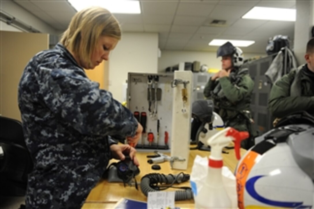 U.S. Navy Airman Jessica Tescher (left), a parachute rigger, performs a monthly maintenance check on a pilot's helmet during Exercise Northern Edge at Joint Base Elmendorf-Richardson, Alaska, on June 16, 2011.  Northern Edge is an annual joint training exercise designed to test military and civilian response and coordination capabilities while enhancing the command, control and communications relationships associated with joint operations.  