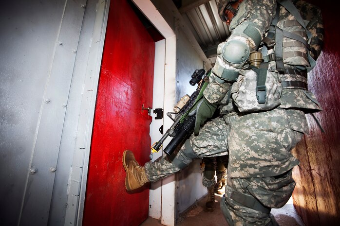 Army Spc. Dallas Cannon, a rifleman with Echo Company, 100th Battalion, 442nd Infantry Regiment, smashes open a door in preparation for clearing the modular armored tactical combat house, or “shoot house,” at the Kaneohe Bay Range Training Facility on Marine Corps Base Hawaii, June 21, 2011. The training evolution was part of the reserve infantry battalion’s annual training package conducted both here and on Schofield Barracks from June 13 to June 30.