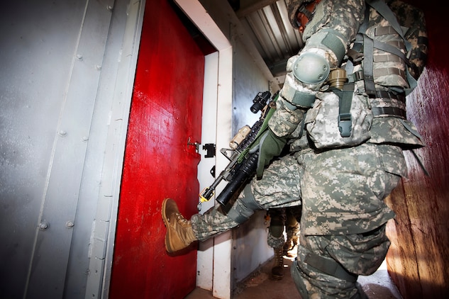 Army Spc. Dallas Cannon, a rifleman with Echo Company, 100th Battalion, 442nd Infantry Regiment, smashes open a door in preparation for clearing the modular armored tactical combat house, or “shoot house,” at the Kaneohe Bay Range Training Facility on Marine Corps Base Hawaii, June 21, 2011. The training evolution was part of the reserve infantry battalion’s annual training package conducted both here and on Schofield Barracks from June 13 to June 30.