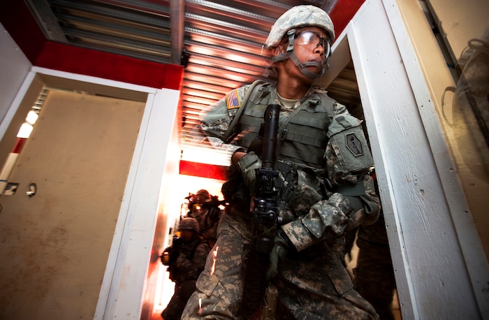 Army Pfc. Patrick Calilung, a rifleman with Echo Company, 100th Battalion, 442nd Infantry Regiment, swiftly moves from one room to the next while clearing the modular armored tactical combat house, or “shoot house,” at the Kaneohe Bay Range Training Facility on Marine Corps Base Hawaii, June 21, 2011. The training evolution was part of the reserve infantry battalion’s annual training package conducted both here and on Schofield Barracks from June 13 to June 30.