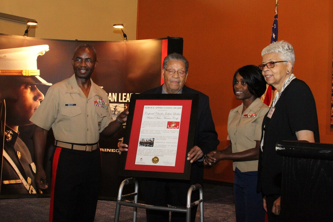 Major Gen. Ronald L. Bailey stands with Charles Lockett, a Montford Point Marine, after he was presented an award June 22 by Evelyn Preston (far right), the president and CEO of the St. Louis African-American Chamber of Commerce, for his contribution to African-Americans through service in the Marine Corps.
