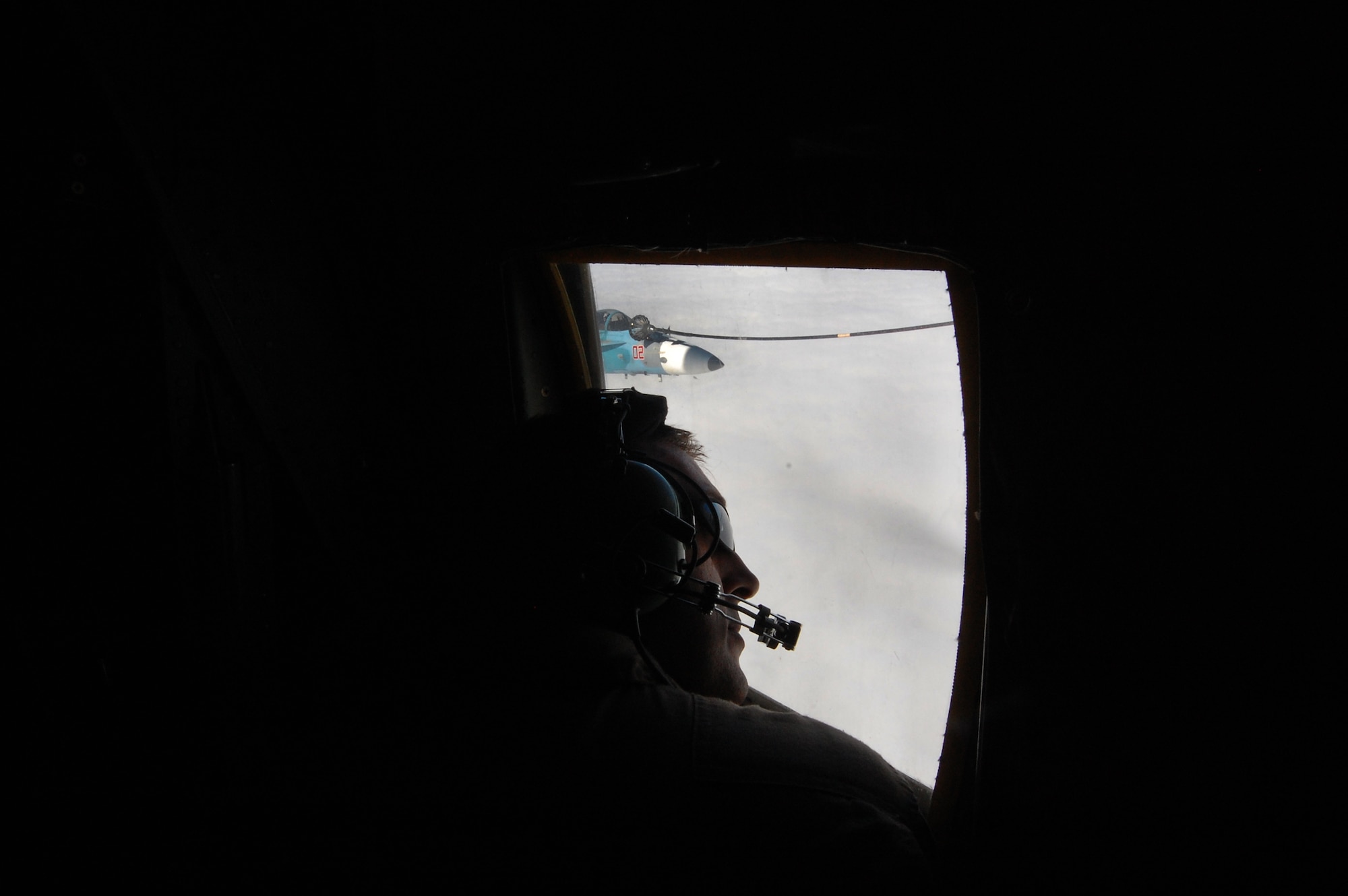 U.S. Marine Corps Sgt. Jason Rudy, a power line shop mechanic with the Marine Aerial Transport Squadron (VMGR) 452, Stewart Air National Guard Base, N.Y., observes an in-flight refueling of an F-18C Hornet from the "Fighting Omars" of Fighter Squadron Composite (VFC) 12 from Naval Air Station Oceana, Virginia Beach, Va.,  during the Northern Edge Premier Joint Training Exercise at the Joint Pacific Alaska Range Complex, June 21.  The VFC 12 unit is a Navy Reserve Fighter Squadron that provides training to east coast air wings. (U.S. Air Force photo/ Staff Sgt. Lakisha A. Croley)