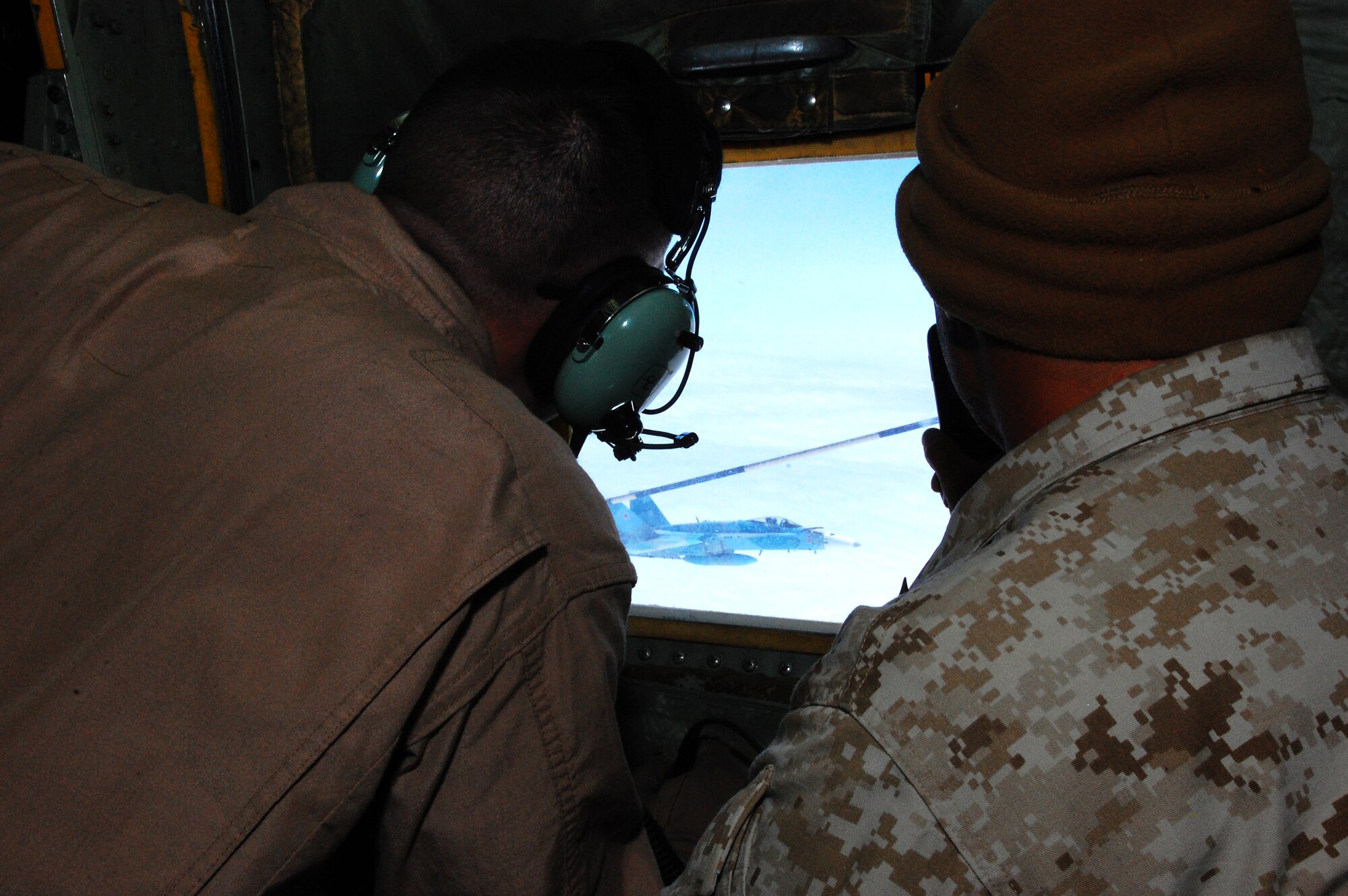 (From left to right)  U.S. Marine Corps Sgt. Jason Rudy, a power line shop mechanic with the Marine Aerial Transport Squadron (VMGR) 452, Stewart Air National Guard Base, N.Y., and Gunnery Sgt. Daniel Martinez, a maintenance chief with the Marine Air Control Squadron 23, Buckley Air Force Base, Colo.,  observe an air-to-air refueling of an F-18C Hornet from the "Fighting Omars" Fighter Squadron Composite (VFC) 12 from the Naval Air Station Oceana, Virginia Beach, Va., during the Northern Edge Premier Joint Training Exercise at the Joint Pacific Alaska Range Complex, June 21. Northern Edge first began in 1993, following a long tradition of exercises such as JACK FROST in 1975, BRIM FROST from 1981-1989 and Arctic Warrior from 1991-1992. (U.S. Air Force photo/Staff Sgt. Lakisha A. Croley)