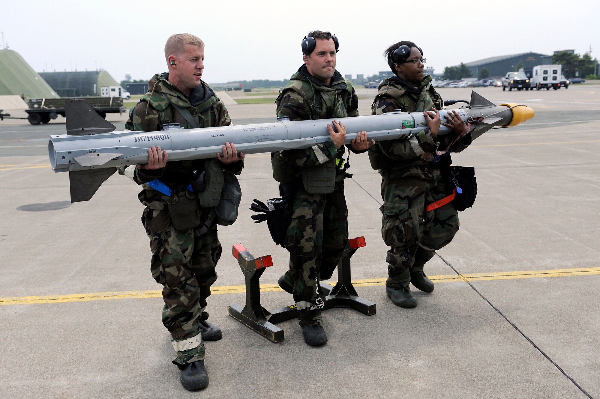 MISAWA AIR BASE, Japan -- Airman 1st Class Nicholas Douglas, Staff Sgt. Patrick Cannon and Senior Airman Alexia Bailey, 14th Aircraft Maintenance Unit weapons loaders, transport an AIM-9 Sidewinder to an F-16 Fighting Falcon during a training exercise June 22. The exercise tested Airmen's ability to survive and operate in a combat environment. (U.S. Air Force photo/Staff Sgt. Marie Brown/Released)
