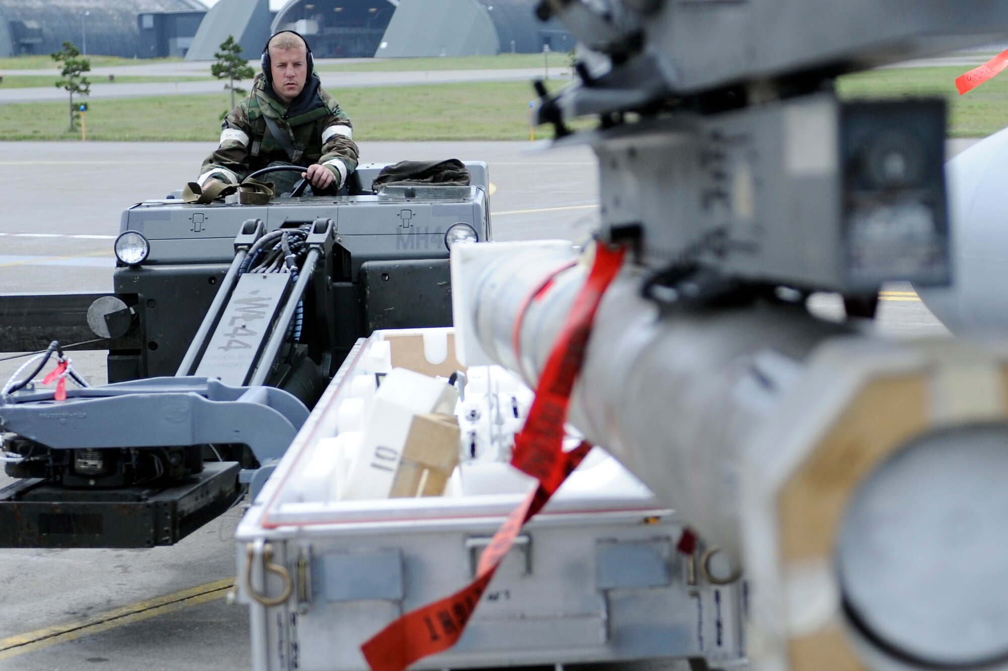 MISAWA AIR BASE, Japan -- Airman 1st Class Nicholas Douglas, 14th Aircraft Maintenance Unit weapons loader, guides a MHU-83 jammer into place to download a AGM-88 high-speed anti-radiation missile during a training exercise June 22. Airmen at Misawa are participating in a week-long exercise designed to test their ability to survive and operate in a combat environment. (U.S. Air Force photo/Staff Sgt. Marie Brown/Released)
