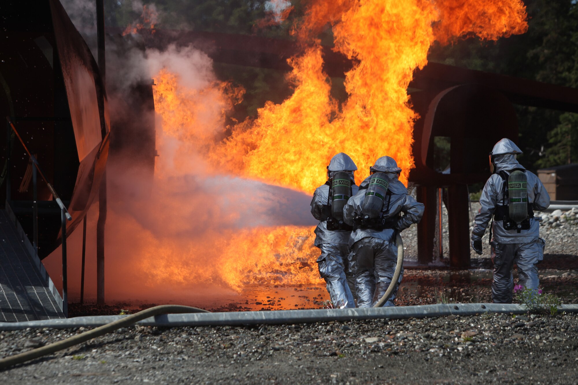 JOINT BASE ELMENDORF-RICHARDSON, Alaska -- Firefighters from the 673rd Civil Engineer Squadron at Joint Base Elmendorf-Richardson complete rescue training June 17, 2011. In addition to maintaining the same training qualifications as civilian firefighters, the Airmen must learn how to rescue aviators from the various aircraft participating in Exercise Northern Edge 11. More than 6,000 servicemembers and 150 aircraft are participating in Alaska's largest military training exercise. (Photo by Marine Cpl. Marionne T. Mangrum)