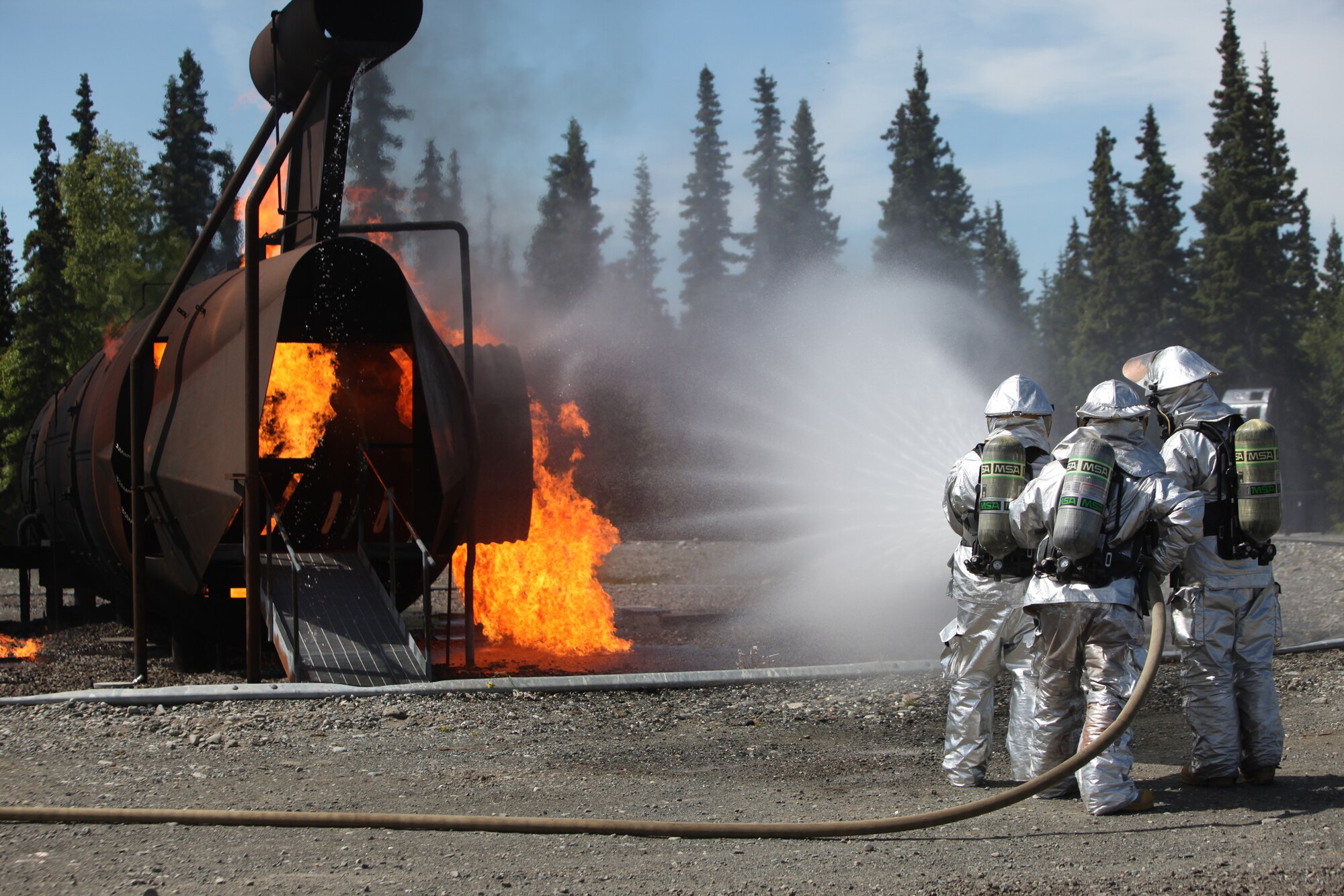 JOINT BASE ELMENDORF-RICHARDSON, Alaska -- Firefighters from the 673rd Civil Engineer Squadron at Joint Base Elmendorf-Richardson complete rescue training June 17, 2011. In addition to maintaining the same training qualifications as civilian firefighters, the Airmen must learn how to rescue aviators from the various aircraft participating in Exercise Northern Edge 11. More than 6,000 servicemembers and 150 aircraft are participating in Alaska's largest military training exercise. (Photo by Marine Cpl. Marionne T. Mangrum)