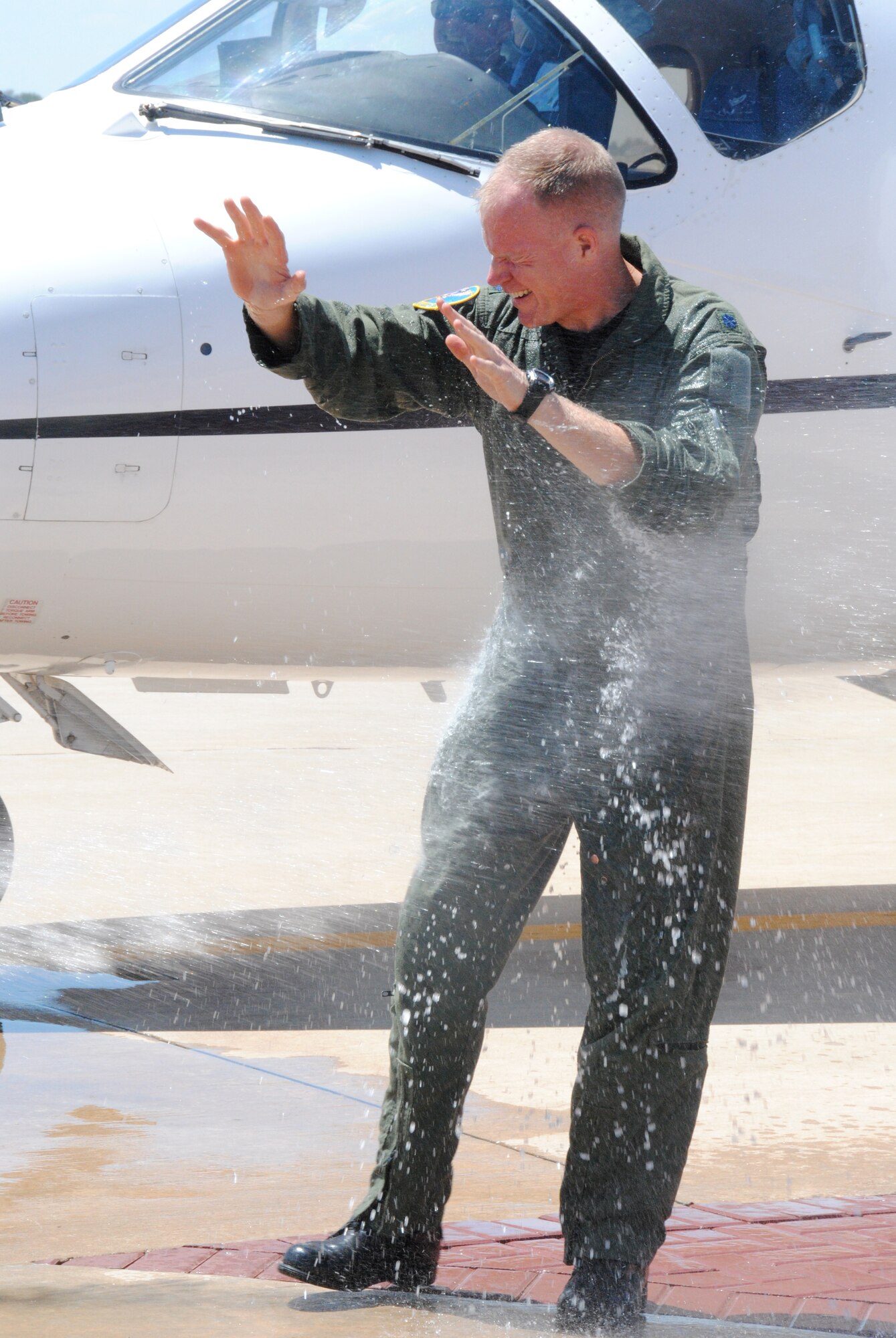 Lt. Col. Darrell Judy receives the traditional soaking by fire hose at the end of his fini flight as the commander of the 32nd Flying Training Squadron June 21 at Vance AFB, Okla. After the squadron’s change of command ceremony at 10 a.m., June 24, in Hangar 199, Colonel Judy will be heading to Stuttgart, Germany. Lt. Col. Michelle Pryor, the current director of operations with the 32nd FTS, will assume command of the squadron. (U.S. Air Force photo/ Zach Sproul)