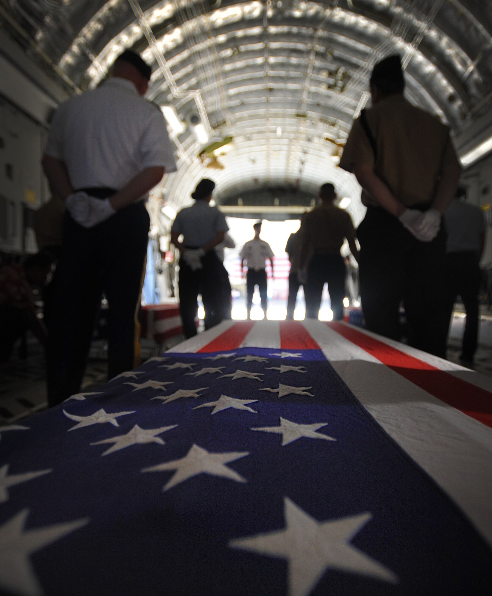 Military members prepare to move the transfer case with the remains of a U.S. service member from a C-17 Globemaster III June 17, 2011, during an arrival ceremony at Joint Base Pearl Harbor-Hickam, Hawaii.  The unidentified remains were recovered by members of the Joint Pacific Accounting Command. Following the ceremony, with full military honors, the remains were sent to JPAC's Central Identification Laboratory where forensic identification analysis will be conducted so they may be identified and returned to member’s family. (U.S. Air Force photo/Senior Airman Lauren Main) 