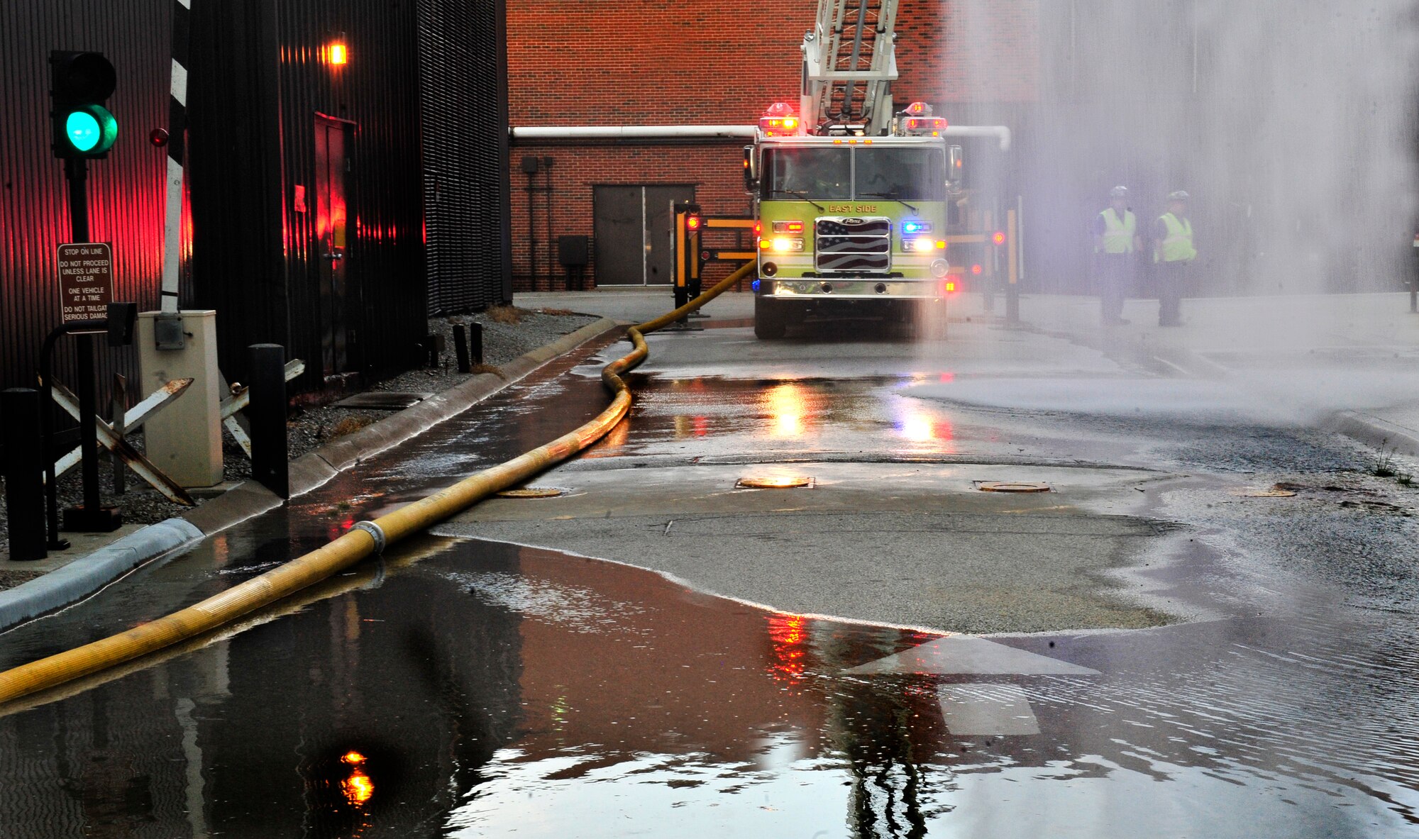 Firemen from the East Side Fire Department in Belleville, Ill., spray water outside of the Air Mobility Command building June 21, 2011 during a training scenario. More than 20 firefighters from surrounding off-base fire departments also participated in this scenario. This was the first time a joint fire training scenario was held at the headquarters building.  (United States Air Force photo/ Staff Sgt. Stephenie Wade) 
