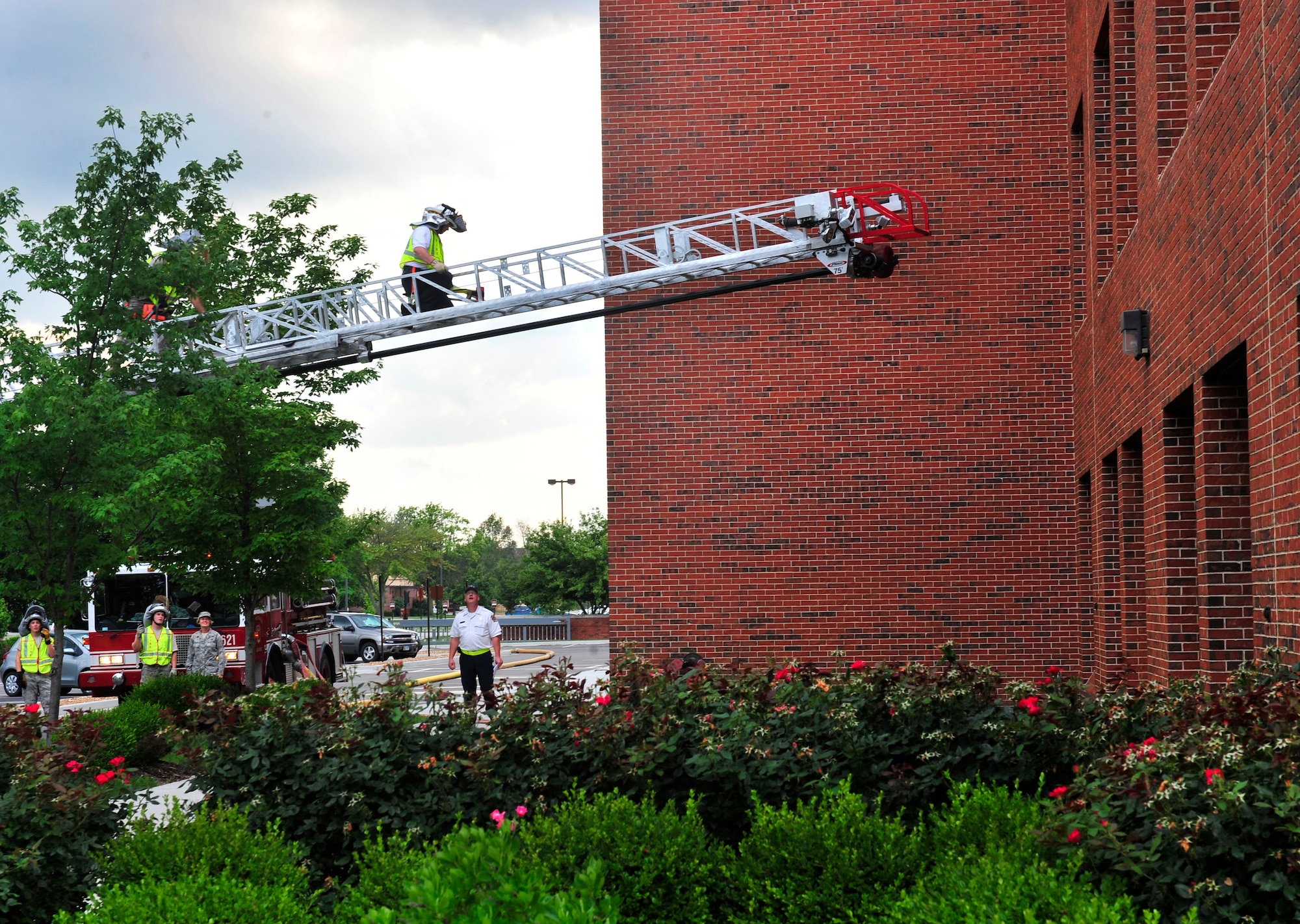 A fireman from 375th Civil Engineer Squadron climbs up a turn table ladder over the Air Mobility Command building June 21, 2011, during a training scenario.  More than 20 firefighters from surrounding off-base fire departments also participated in this scenario. This was the first time a joint fire training scenario was held at the headquarters building.   (United States Air Force photo/ Staff Sgt. Stephenie Wade)