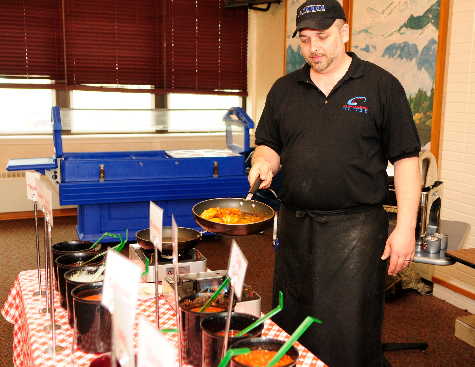James Clerc lays a skillet of chicken wings to the flame June 15, 2011, Eielson Air Force Base, Alaska.  Mr. Clerc, better known as Buddha, plans to retire from the kitchen after working several years with the Yukon Club helping make it a success.  Mr. Clerc is assigned to the 354th Force Support Squadron. (U.S. Air Force photo/Airman 1st Class Yash Rojas)