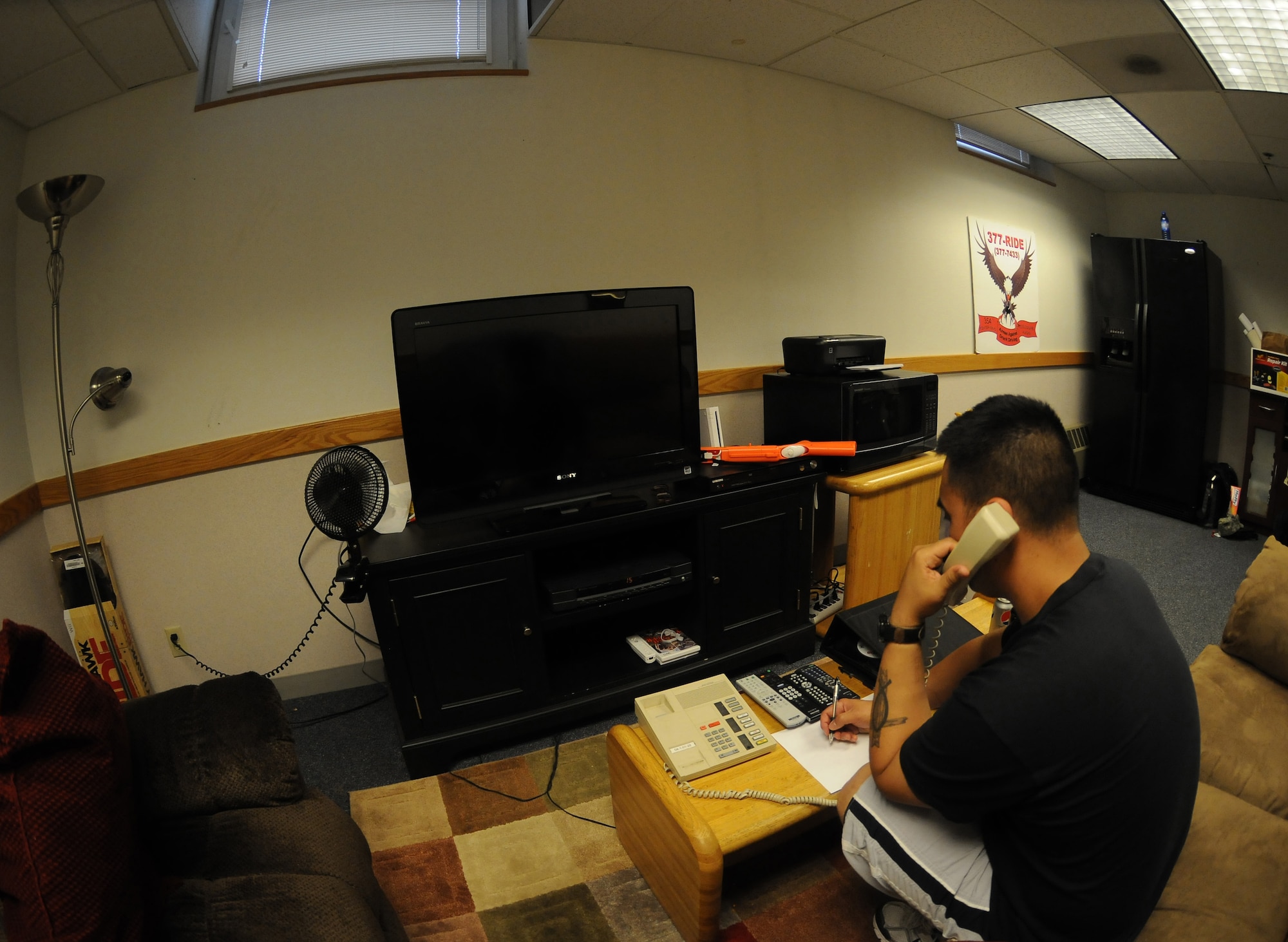 Tech. Sgt. Gabriel Hayashi answers the Airmen Against Drunk Driving phone June 17, 2011, Eielson Air Force Base, Alaska. Volunteers in the CQ area can use the TV, play games and eat snacks while they wait for calls. Sergeant Hayashi is assigned to the 354th Maintenance Squadron. (U.S. Air Force photo by/Airman 1st Class Janine Thibault)