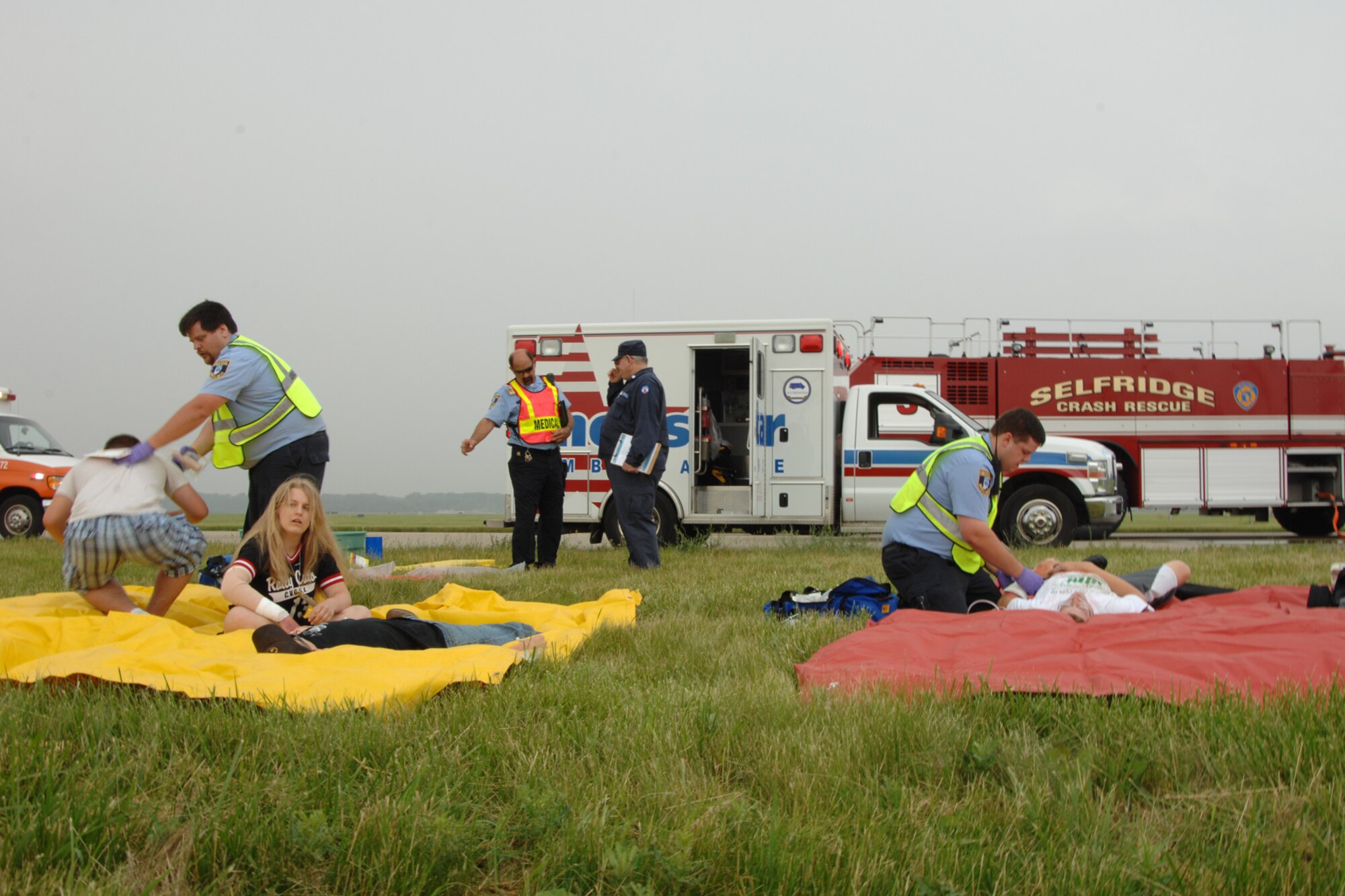 Selfridge firefighters work with emergency medical technicians from the MedStar ambulance service to treat people with simulated casualties during a Major Accident Response Exercise at Selfridge Air National Guard Base, Mich., June 21, 2011. Military planners at the base often invite local agencies, such as MedStar, to participate in base exercises to enhance the readiness of all personnel to respond to a major incident. (USAF photo by Rachel Barton, 127th Wing Public Affairs)