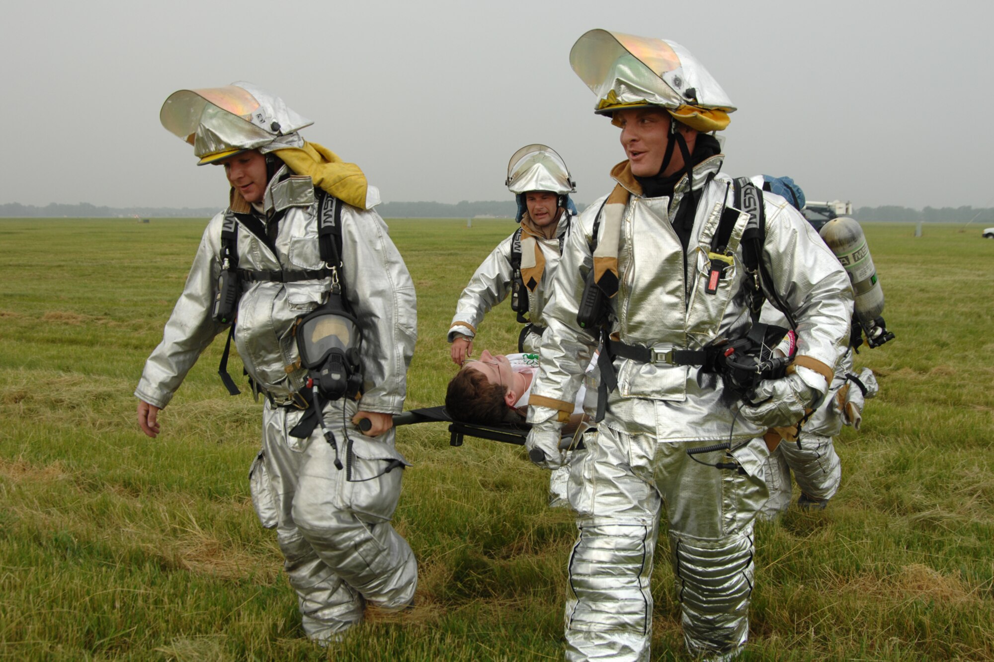 Military firefighters carry a simulated accident victim to safety during a Major Accident Response Exercise at Selfridge Air National Guard Base, Mich., June 21, 2011. The 127th Wing at Selfridge routinely conducts such exercises to enhance the readiness of base personnel in the case of a major accident on or near the base. (USAF photo by Rachel Barton, 127th Wing Public Affairs)