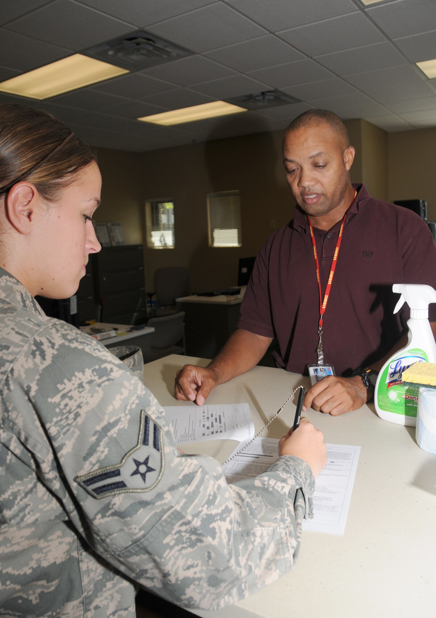Airman 1st Class Stephanie Fitzpatrick, left, 81st Surgical Operations Squadron, fills out the proper paper work to be checked into a permanent party dorm by Mr. Walden.  (U.S. Air Force photo by Kemberly Groue)